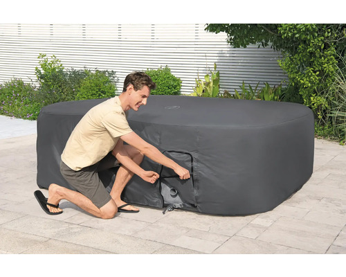 Mann öffnet die Abdeckung eines Whirlpools im Garten.