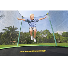 Ein Junge springt auf einem Bestway-Trampolin mit Sicherheitsnetz im Garten.