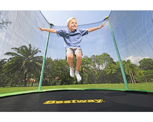 Ein Junge springt auf einem Bestway-Trampolin mit Sicherheitsnetz im Garten.