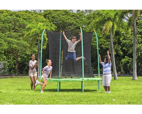 Trampolin mit Sicherheitsnetz im Garten mit spielenden Kindern