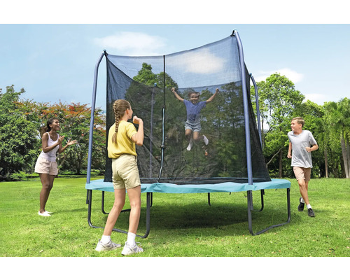 Rechteckiges Gartentrampolin mit Sicherheitsnetz und spielenden Kindern im Garten