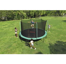 Trampolin mit Sicherheitsnetz im Garten mit spielenden Kindern