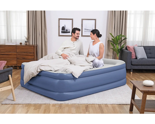 Aufblasbares Doppelbett mit zwei Personen im Schlafzimmer.
