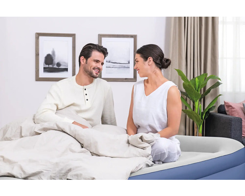Paar sitzt auf einem Luftbett im Schlafzimmer