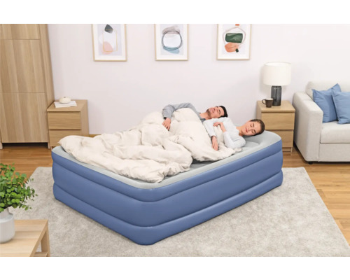 Aufblasbares Gästebett mit schlafendem Paar im Schlafzimmer.
