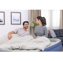 Paar entspannt auf einem Luftbett im Wohnzimmer.