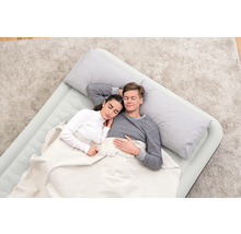 Ein Paar schläft auf einer Luftmatratze mit Kissen und Decke.