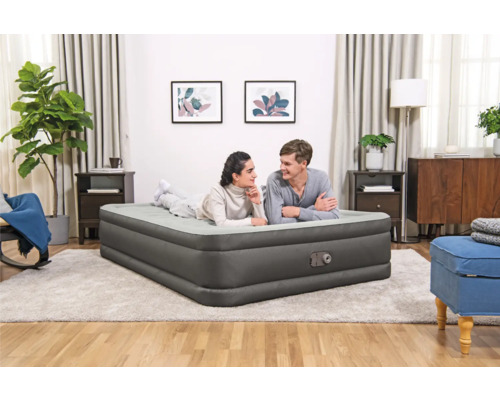 Ein Paar entspannt sich auf einem Luftbett in einem Wohnzimmer.