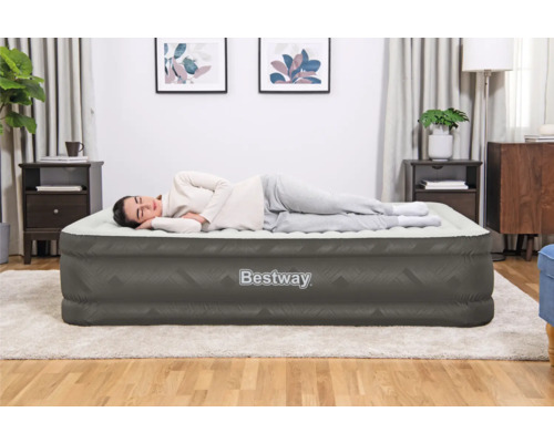 Frau liegt auf einer grauen Bestway Luftmatratze in einem Schlafzimmer.