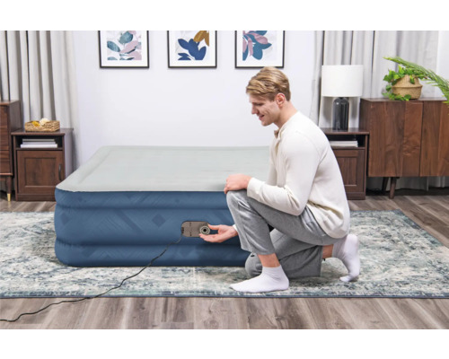 Aufblasbares Gästebett mit integrierter Pumpe in einem Wohnraum.