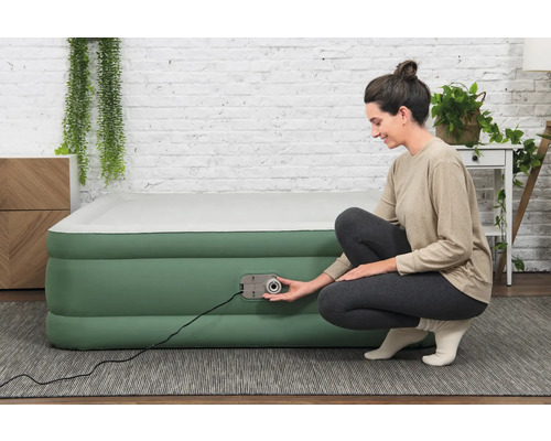 Aufblasbares Gästebett mit integrierter Pumpe und einer Frau, die die Pumpe bedient
