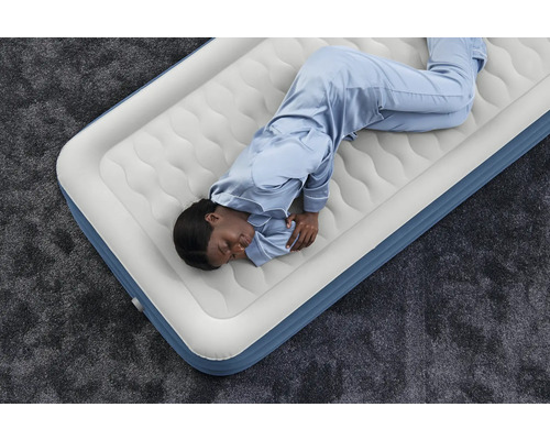 Aufblasbare Matratze mit schlafender Person auf einem Teppich
