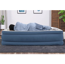 Person liegt auf einer blauen Luftmatratze im Raum.