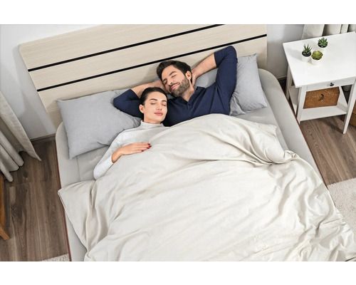 Schlafendes Paar im Bett mit Bettwäsche, Kissen und Nachttisch