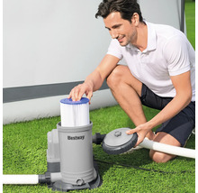 Mann setzt Filter in Bestway Filterpumpe auf Rasen