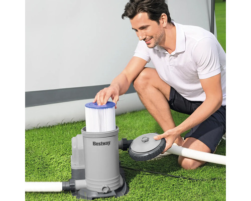 Mann setzt Filter in Bestway Filterpumpe auf Rasen