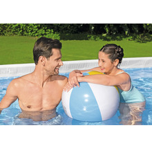 Vater und Tochter spielen mit einem Ball im Pool.