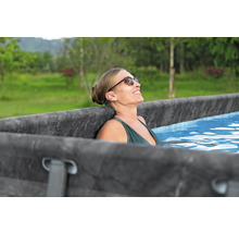 Frau entspannt in einem Frame-Pool im Garten.