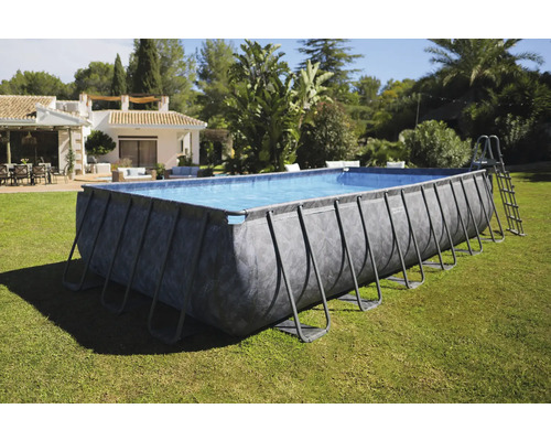 Rechteckiger Frame-Pool mit Leiter auf Rasen vor einem Haus