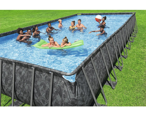 Rechteckiger Pool mit Stahlrahmen und darin badende Personen auf einer grünen Rasenfläche