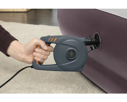 Eine Hand hält eine elektrische Luftpumpe an einem aufblasbaren Objekt
