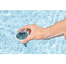 Hand hält ein Solar-Poolthermometer im Wasser.