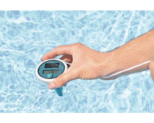 Hand hält ein Solar-Poolthermometer im Wasser.