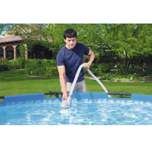 Mann reinigt Pool mit Poolsauger im Garten.