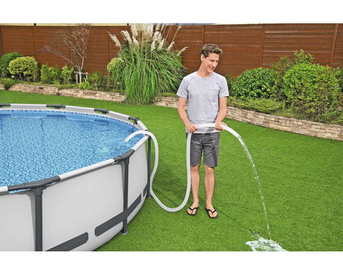 Aufbaubecken im Garten wird mit einem Schlauch entleert.