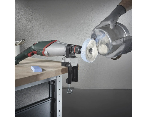 Bohrmaschine mit Polieraufsatz und Schraubstock am Werktisch beim Polieren eines Metalleimers