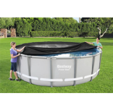 Personen decken einen runden Pool mit einer Poolabdeckung ab.
