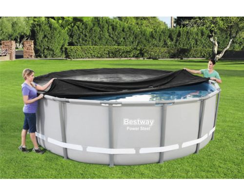Personen decken einen runden Pool mit einer Poolabdeckung ab.