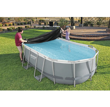 Personen legen eine Schutzplane auf einen rechteckigen Pool im Garten