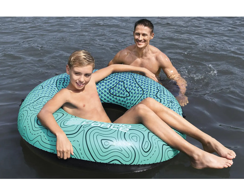 Junge mit Schwimmreifen und Mann im Wasser