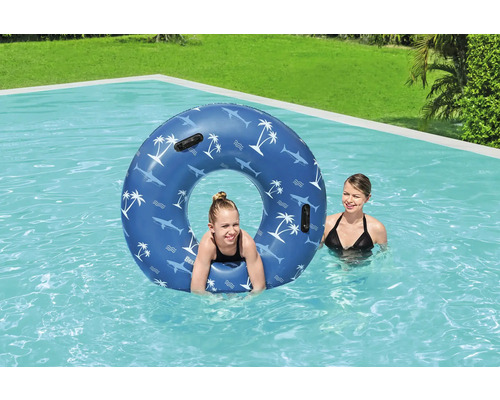 Person mit Schwimmreifen im Pool mit Haifischmuster