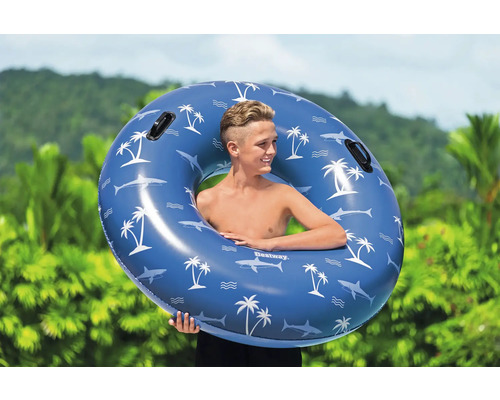 Junge mit blauem Bestway Schwimmring mit Hai- und Palmenmuster