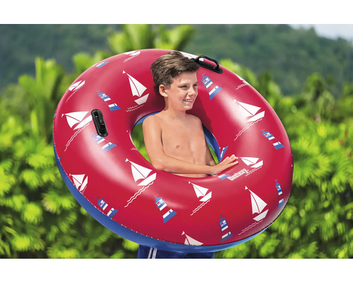 Kind mit aufblasbarem Schwimmreifen mit Segelboot- und Leuchtturmmuster