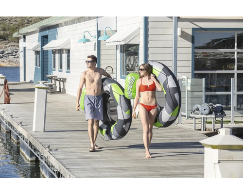 Ein Mann und eine Frau tragen auf einem Steg Wasserschläuche.