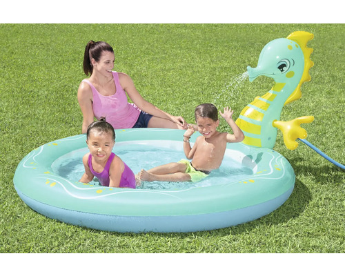 Aufblasbares Planschbecken mit Kindermotiv und Wassersprinkler im Garten.