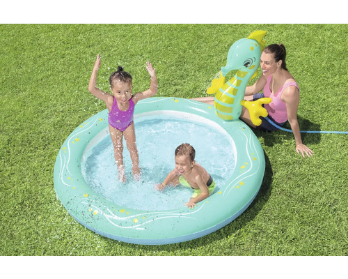 Aufblasbarer Kinderpool mit Wassersprinkler in Form eines Seepferdchens im Garten mit spielenden Kindern