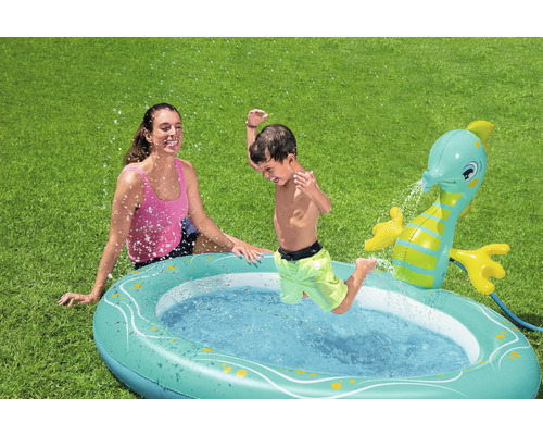 Planschbecken mit Wassersprinkler und spielendem Kind im Garten