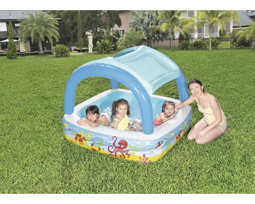 Aufblasbares Planschbecken mit Sonnenschutz und Kindern im Garten.