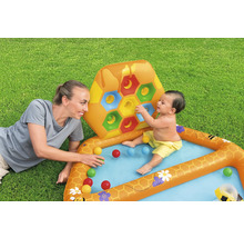 Aufblasbares Planschbecken mit Bienenwabenmuster, Bällen und spielender Mutter mit Baby auf einer Rasenfläche.