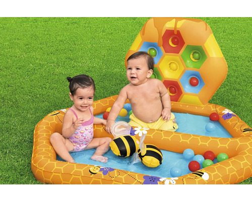 Aufblasbares Planschbecken mit Bällen und Bienen-Wassersprinkler für Kinder im Garten.
