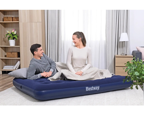 Szene mit einem Paar auf einer blauen Bestway Luftmatratze in einem Wohnzimmer.