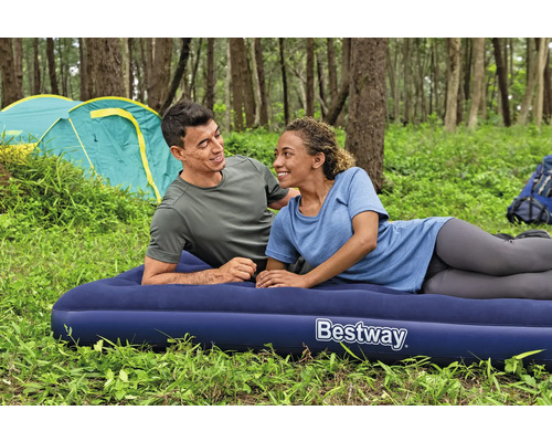 Ein Paar entspannt auf einer blauen Bestway Luftmatratze beim Camping im Wald