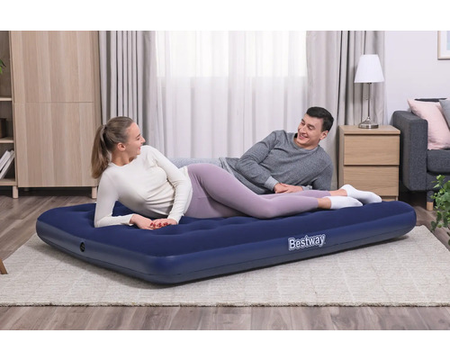 Paar entspannt auf einer blauen Bestway Luftmatratze im Wohnzimmer.