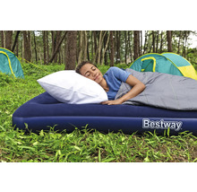 Frau schläft auf einer Luftmatratze mit Kissen und Schlafsack im Freien, mit dem Bestway Logo.