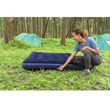 Frau bereitet Luftmatratze zum Campen vor