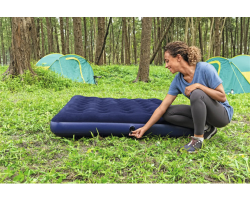 Frau bereitet Luftmatratze zum Campen vor